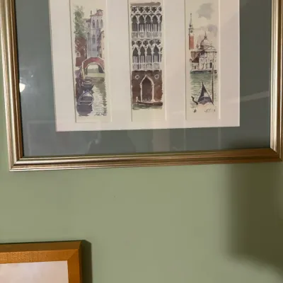 Framed triptych watercolor print depicting Venetian canals and architecture, presented in a metallic silver-and-gold frame with double...