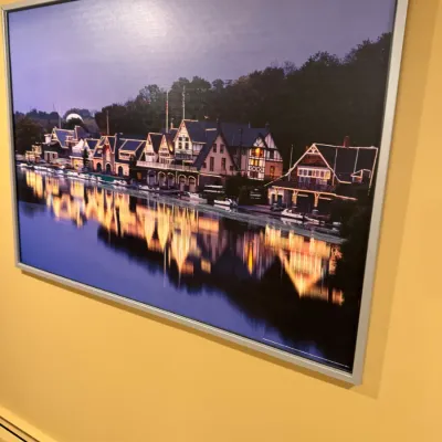 Large framed photographic print depicting Boathouse Row in Philadelphia illuminated at night, presented in a silver-tone metal frame.