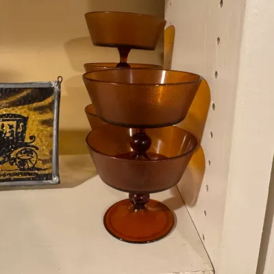Stack of amber glass dessert cups featuring textured bowls and pedestal bases, mid-20th century.