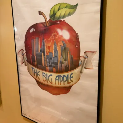 Framed vintage New York City "The Big Apple" poster featuring the Twin Towers and Manhattan skyline inside an apple graphic.