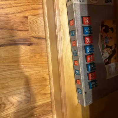Vintage Milton Bradley Stratego board game in its original box, resting on a wooden shelf.