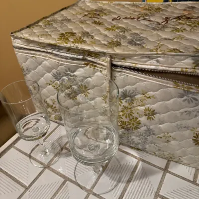 Vintage quilted floral stemware storage case displayed alongside two clear crystal goblets.