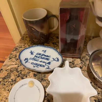 Collection of small decorative ceramics and table accessories, featuring an oval garden-quote dish, a leaf-shaped dish, a horse mug, and...