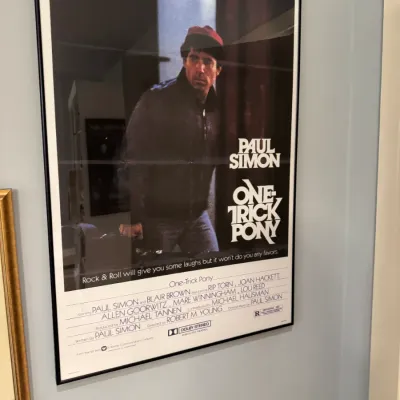 Framed original movie poster for Paul Simon's 1980 drama One-Trick Pony, displayed in a simple black frame under glass.