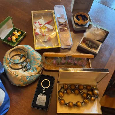 Collection of vintage fashion jewelry and accessories, including boxed beaded necklaces, a Bloomingdale's keychain, a watch, and...