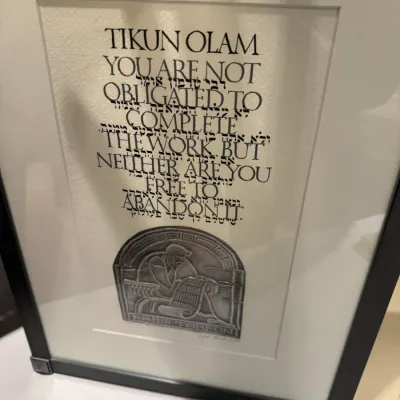 Framed Judaica calligraphic art print featuring the 'Tikun Olam' quote by Rabbi Tarfon over Hebrew text, accompanied by an...