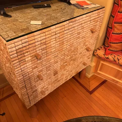 Handcrafted three-drawer dresser covered in recycled wine corks, topped with a protective glass surface.