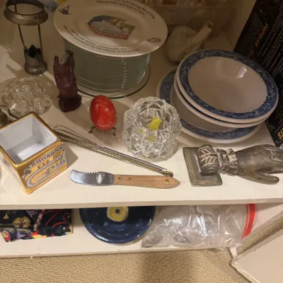 Collection of shelf items including Peter Rabbit china, a cut glass votive holder, blue and white bowls, small utensils, and decorative...