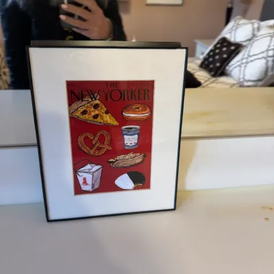 Framed reproduction print of a New Yorker magazine cover featuring illustrations of classic New York foods on a red background.