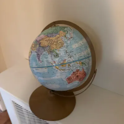 Vintage desktop world globe on a gold-toned metal stand.