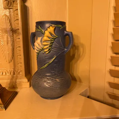 Roseville Pottery Freesia pattern double-handled vase in blue, featuring raised yellow and white floral details and a textured wave base,...