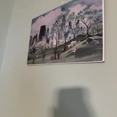 Framed impressionistic painting depicting Central Park with the New York City skyline in the background, signed by the artist at the...
