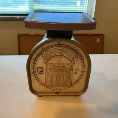 Sale Photo Thumbnail #38: Vintage Pelouze Model Y-5 postal scale, displaying various rate charts with minor surface wear.