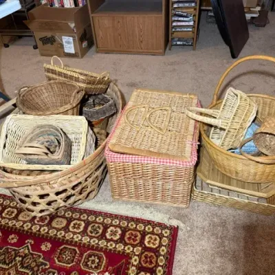 Sale Photo Thumbnail #355: Collection of vintage woven wicker and rattan baskets in various shapes and sizes, including a picnic basket with a red gingham lining.