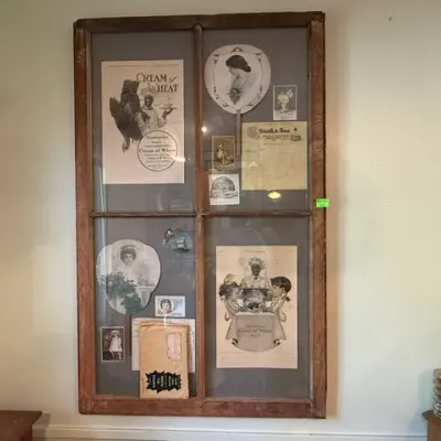 Sale Photo Thumbnail #302: Rustic wall-mounted multi-pane window frame displaying vintage ephemera, including vintage Cream of Wheat advertisements, hand fans, and postcards.