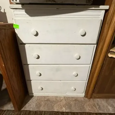 Sale Photo Thumbnail #361: White painted wooden four-drawer chest with matching round knobs, showing minor wear on the finish.