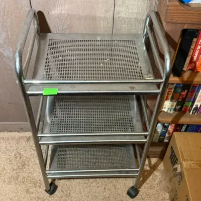 Sale Photo Thumbnail #335: Vintage three-tier metal rolling utility cart with perforated shelves and casters.
