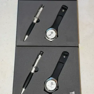 Sale Photo Thumbnail #63: Two boxed General Motors commemorative sets, each featuring a silver-and-black pen and matching wristwatch housed in custom foam inserts.