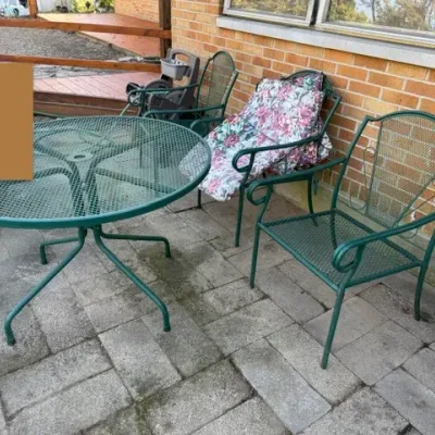 Sale Photo Thumbnail #497: Green wrought iron wrought-and-mesh patio set featuring a round mesh-top table and matching armchairs with floral cushions.