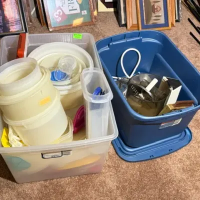 Sale Photo Thumbnail #339: Two storage totes filled with assorted vintage kitchenware, including plastic Tupperware containers, bowls, and food processor attachments.