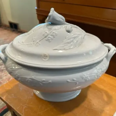 Sale Photo Thumbnail #15: White porcelain covered tureen featuring embossed floral and leaf details with a rosebud finial lid.