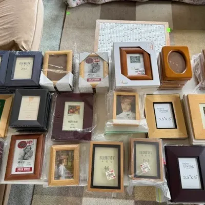 Sale Photo Thumbnail #188: Large assortment of assorted picture frames in various sizes, styles, and wood finishes, many still in original packaging.