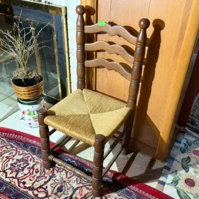 Sale Photo Thumbnail #258: Vintage ladder-back dining chair featuring turned wooden posts, finial tops, and a woven rush seat.