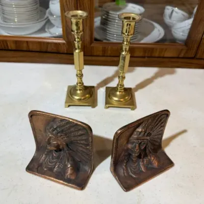 Sale Photo Thumbnail #113: Pair of vintage brass candlestick holders and a set of cast metal Native American chief bookends.