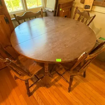 Sale Photo Thumbnail #308: Round rustic wood dining table with turned legs, accompanied by four matching press-back chairs.