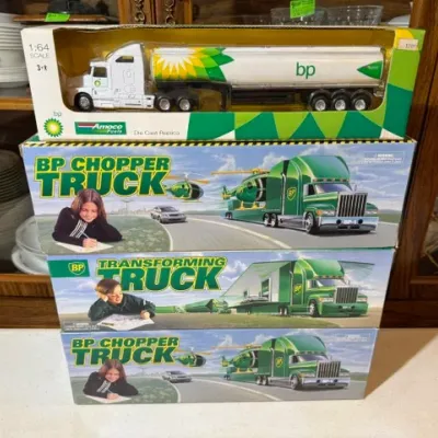 Sale Photo Thumbnail #101: Stack of vintage boxed BP branded toy trucks, including a 1:64 scale die-cast tanker replica, two Chopper Trucks, and a Transforming Truck.