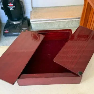 Sale Photo Thumbnail #249: Polished cherry-finish wooden storage box with dual sliding lid panels and a red felt-lined interior.