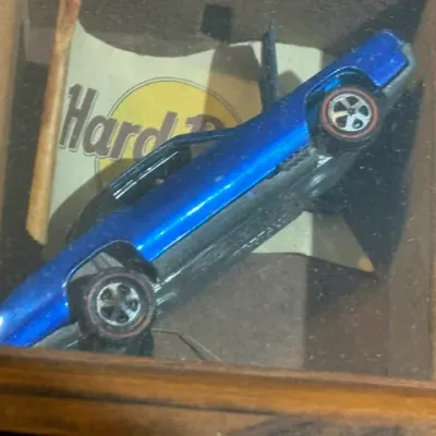 Sale Photo Thumbnail #266: Vintage Hot Wheels Redline die-cast car in metallic blue, displayed in a wooden shadow box.