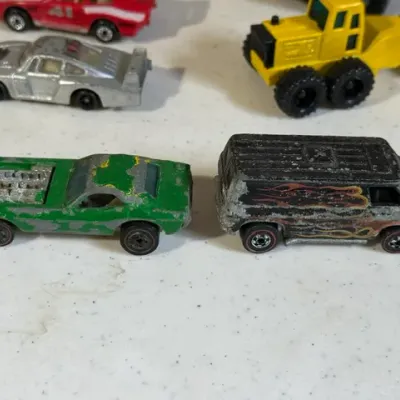 Sale Photo Thumbnail #423: Vintage Hot Wheels Redline die-cast toy cars in heavily played-with condition, showing significant paint loss and wear.
