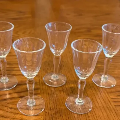 Sale Photo Thumbnail #26: Set of five vintage clear glass cordial glasses featuring panel optic bowls and knoppes stems.