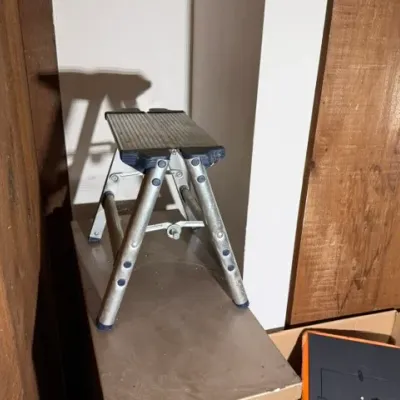 Sale Photo Thumbnail #393: Compact metal folding step stool with a textured top platform, showing light wear.