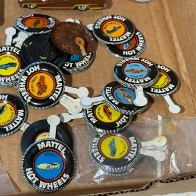 Sale Photo Thumbnail #65: Collection of vintage Mattel Hot Wheels collector buttons from the late 1960s to early 1970s, featuring various car models.