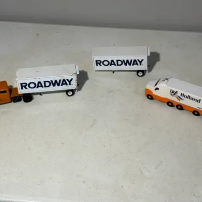Sale Photo Thumbnail #417: Collection of three miniature toy semi-trucks and trailers, featuring Roadway Express and USF Holland branding.