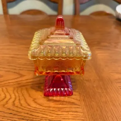 Sale Photo Thumbnail #27: Vintage Amberina carnival glass covered candy dish with a footed square base and decorative finial.