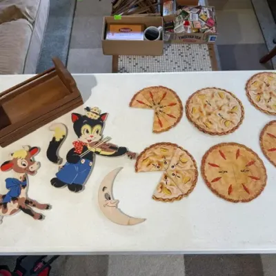 Sale Photo Thumbnail #226: Vintage educational classroom aids, including a set of pie-shaped fraction cutouts, storybook character cutouts, and a small wooden caddy.