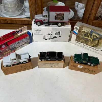 Sale Photo Thumbnail #106: Collection of vintage die-cast collectible vehicles and a miniature metal bicycle, including boxed trucks and cars from various promotional series.