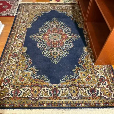 Sale Photo Thumbnail #137: Traditional Persian-style area rug featuring a central medallion on a navy blue field with intricate floral borders and fringed edges.