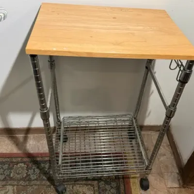 Sale Photo Thumbnail #391: Rolling microwave or utility cart featuring a light wood laminate top, chrome wire rack frame, and caster wheels.