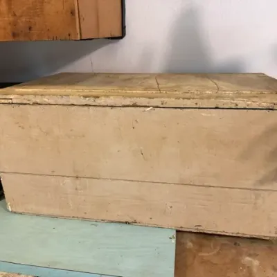 Sale Photo Thumbnail #396: Rustic, light-tan painted wooden storage chest showing weathered surfaces and panel construction.