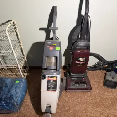 Sale Photo Thumbnail #321: Regina Steemer Ultra 8.0 carpet cleaner, Hoover WindTunnel upright vacuum, and a Sanitaire canister vacuum alongside a wire rack shelf.