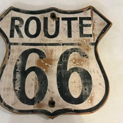 Sale Photo Thumbnail #68: Vintage-style wooden Route 66 highway shield sign featuring distressed black lettering on an off-white background with simulated wear.