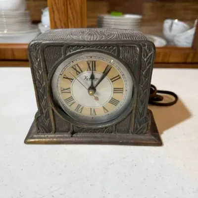 Sale Photo Thumbnail #110: Vintage Art Deco Kenmore electric mantel clock with a textured metal case and Roman numeral dial.