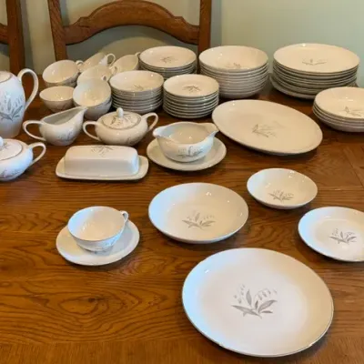 Sale Photo Thumbnail #17: Large fine china dinnerware service featuring a lily of the valley pattern with silver trim, including plates, bowls, teacups, serving platters, and teapot.