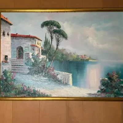 Sale Photo Thumbnail #263: Framed oil painting on canvas depicting a Mediterranean coastal village scene, housed in a thin gold-toned wooden frame.