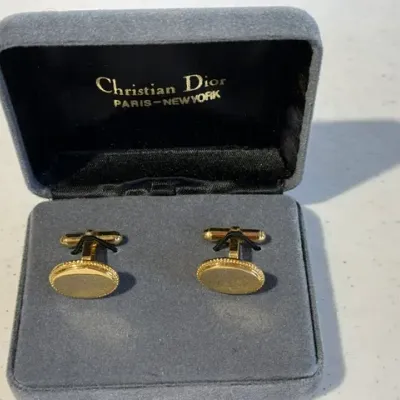 Sale Photo Thumbnail #228: Vintage Christian Dior gold-tone oval cufflinks in their original grey velour display box.