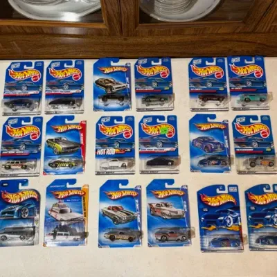 Sale Photo Thumbnail #85: Collection of 18 packaged Hot Wheels die-cast toy cars from the late 1990s and 2000s, including First Editions and special series models.